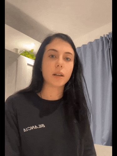 a woman wearing a black shirt that says aiomajib on it