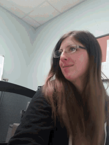 a woman wearing glasses and a black shirt