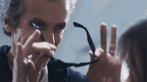 a man is holding a pair of glasses over a woman 's eyes .