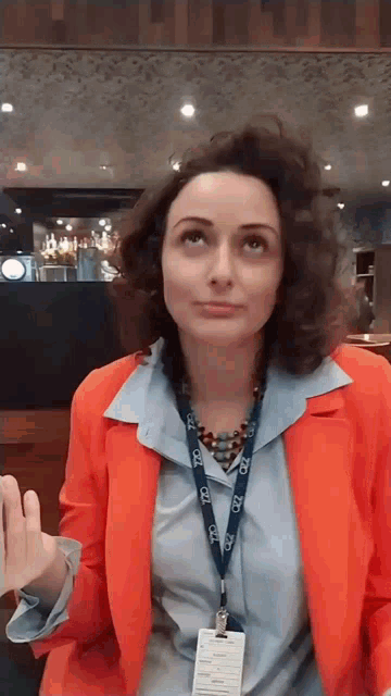 a woman wearing an orange jacket and a lanyard that says ccl