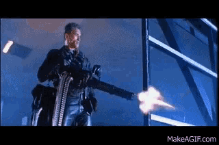 a man is holding a machine gun that is being fired