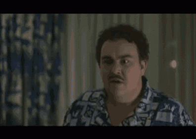 a man with a mustache is making a funny face in front of a window .