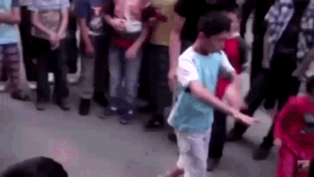 a boy is dancing in front of a crowd of people