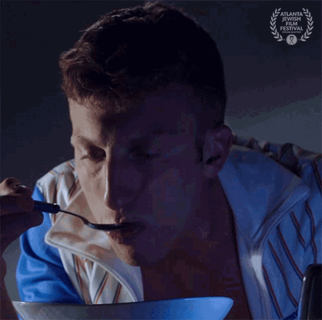a man is eating from a bowl with a atlanta international film festival laurel on the bottom right