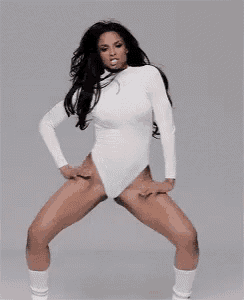 a woman in a white bodysuit is dancing with her legs crossed