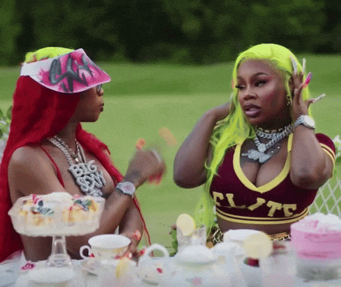 two women are sitting at a table and one has a shirt that says flute on it
