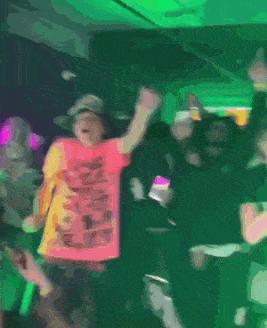 a man in a pink shirt that says ' i love you ' on it is dancing in a crowd