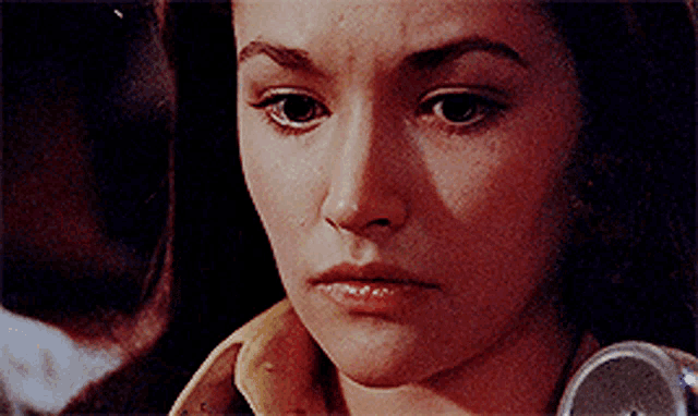a close up of a woman 's face with a yellow shirt