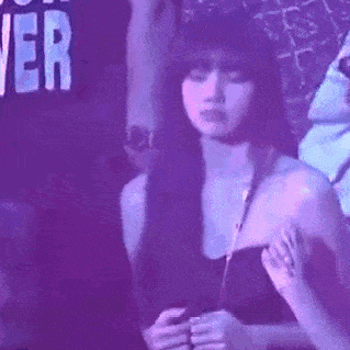 a woman in a strapless top is sitting in a dark room .