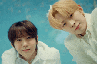 two young men are standing next to each other and looking up at the camera