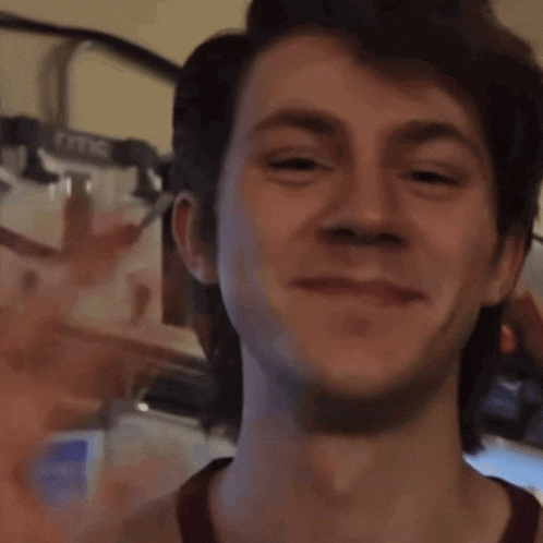 a close up of a man 's face with a thermostat in the background