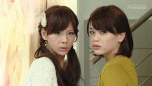 two girls are standing next to each other and one of them has a yellow sweater on