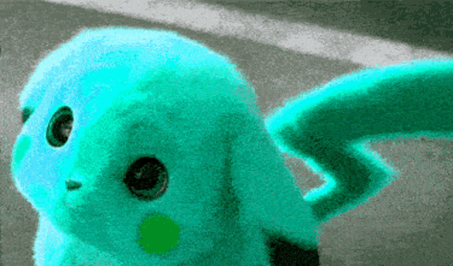a turquoise stuffed animal with a green tail is sitting on the ground