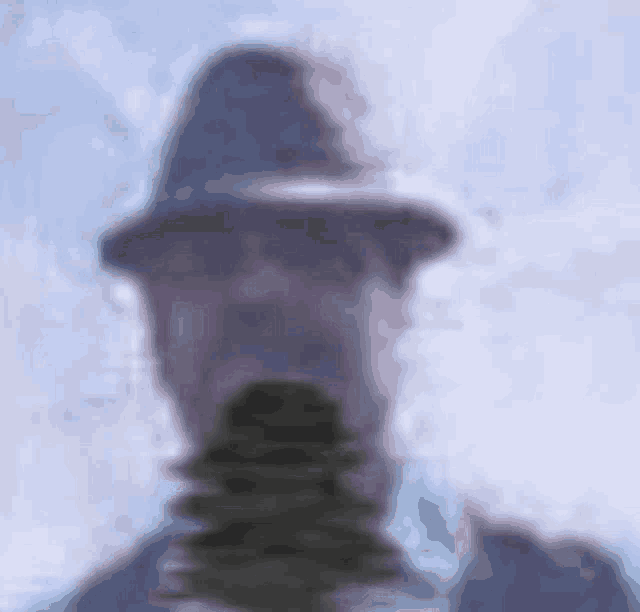 a blurry picture of a man wearing a hat and a suit