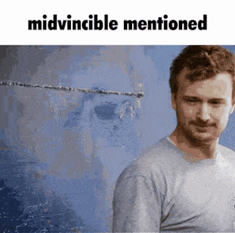 a man standing in front of a blue wall with the words midvincible mentioned below him