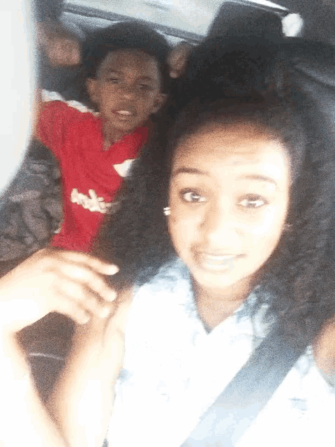 a boy in a red shirt that says brooklyn is sitting next to a girl
