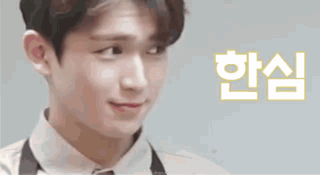 a close up of a young man wearing an apron and a white shirt making a funny face .