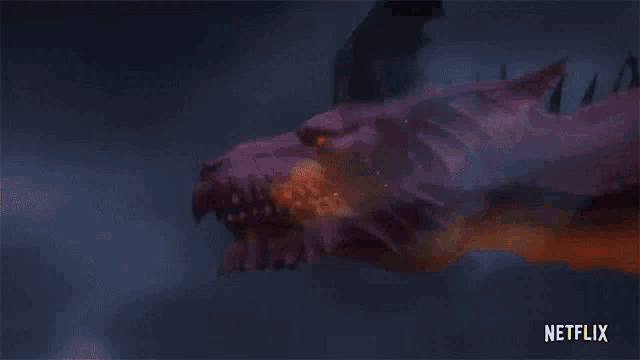 a close up of a dragon 's head with fire coming out of its mouth .