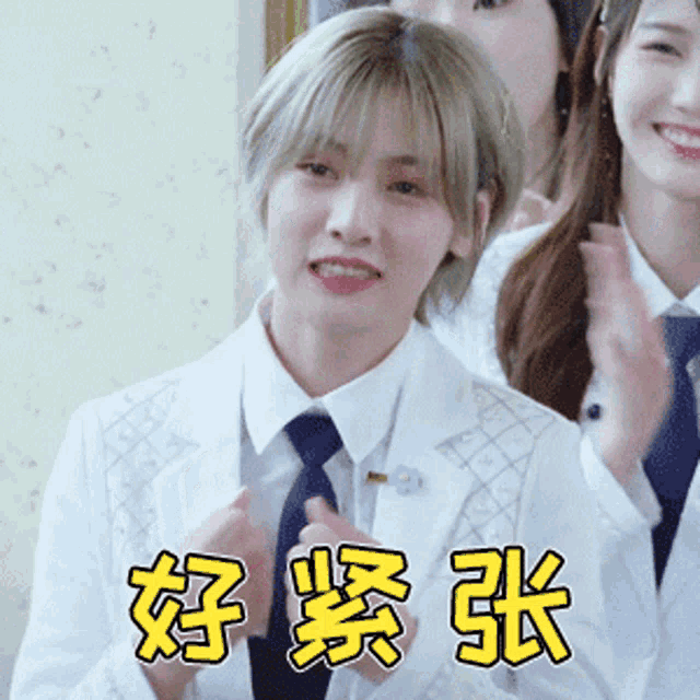 a woman wearing a white suit and tie is clapping her hands
