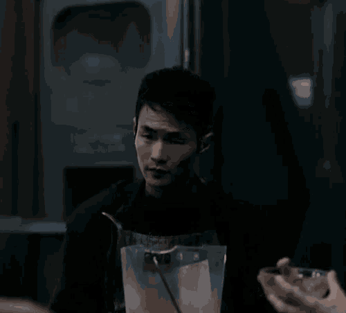 a man is holding a blender with a straw in it and making a funny face .