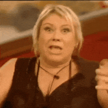 a woman in a black top is making a face