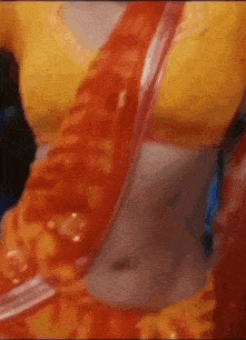 a close up of a woman 's stomach in a yellow blouse and red sash .