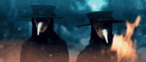 two plague doctors standing next to each other with a fire in the background