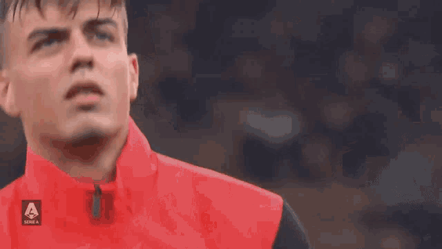 a man wearing a red shirt with the letter a on the front
