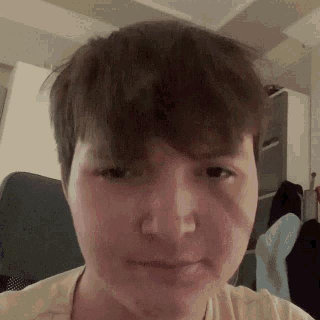 a close up of a person 's face with a messy haircut .