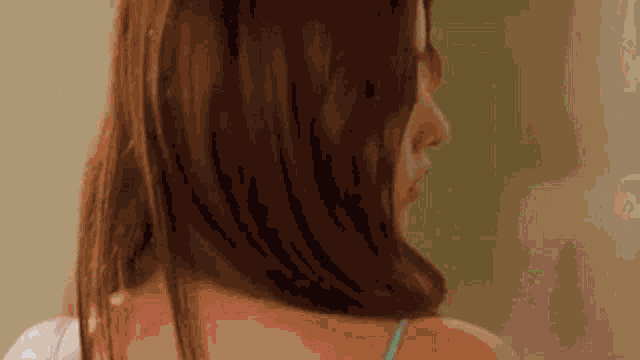 a woman in a blue bra is standing in front of a mirror and looking at herself .