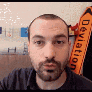 a man with a beard is standing in front of a sign that says deviation