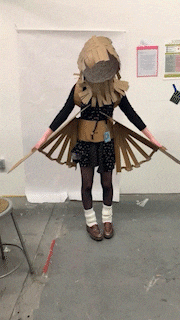 a woman in a cardboard costume has a badge on her waist