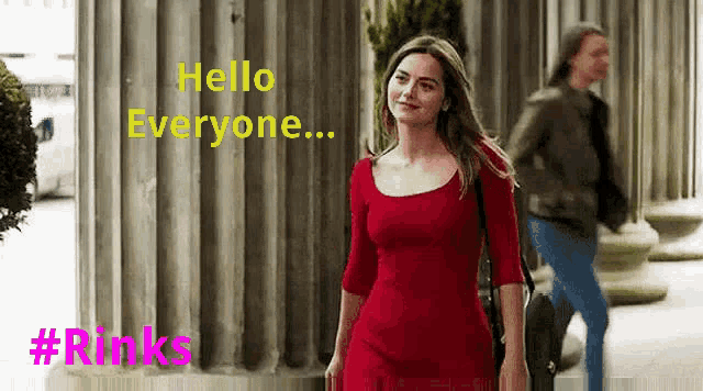 a woman in a red dress is walking down a street with a man walking behind her .