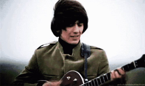 a man in a green jacket is playing a guitar outdoors .