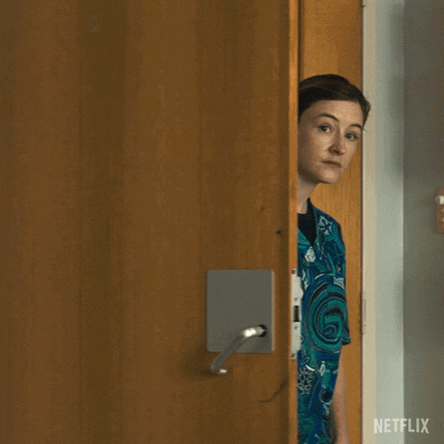a woman in a scrub is standing in a doorway and says you have a visitor