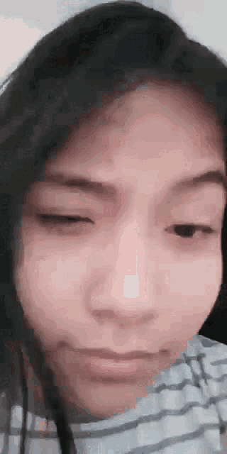 a close up of a young girl 's face with her eyes closed