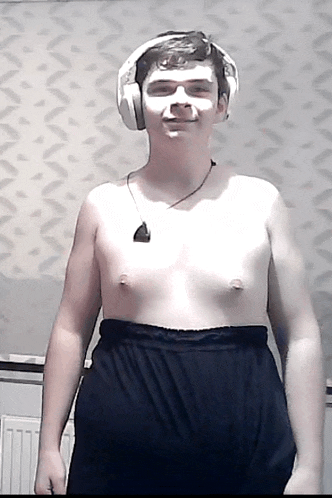 a shirtless man wearing headphones and a necklace