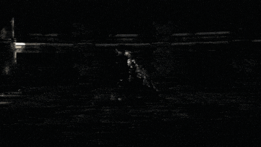 a black and white photo of a person standing in the dark
