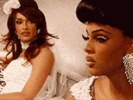 two women in wedding dresses are sitting next to each other