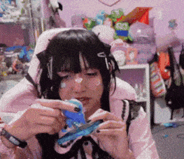 a girl in a pink shirt is holding a ruler in her hands