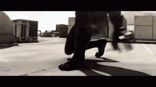 a black and white photo of a person crawling on a sidewalk .