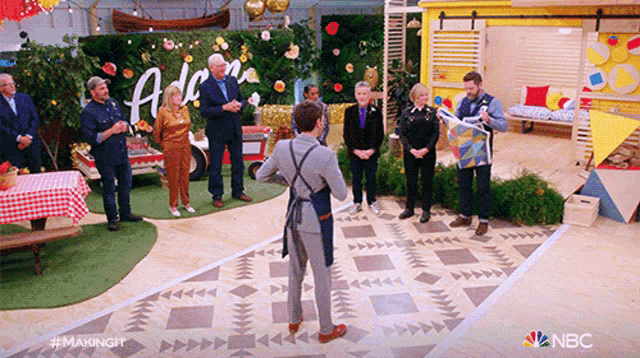 a group of people standing in a room with a sign that says aloha on it