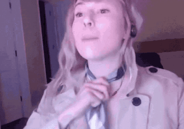a woman wearing a trench coat and a scarf around her neck .