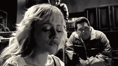 a woman is crying in a black and white photo while a man watches .