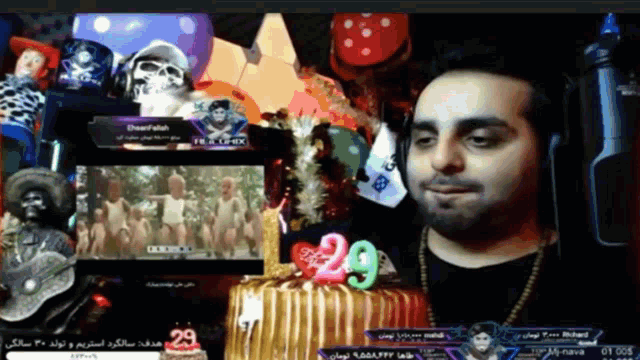 a man wearing headphones stands in front of a cake with a number 29 on it