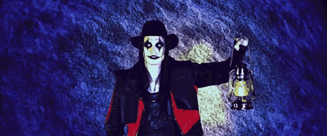 a man in a black and red outfit is holding a lantern in his hand