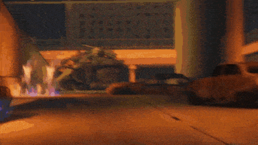 a car is driving down a street at night in front of a building on fire .