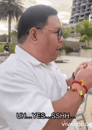 a man wearing glasses and bracelets says uh yes sshh vivavideo