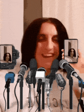 a woman is standing in front of a bunch of microphones