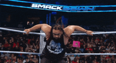 a man in a wrestling ring with the word smack down in the background